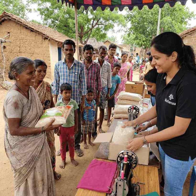 Volunteers handing out supplies to families gathered in a village street