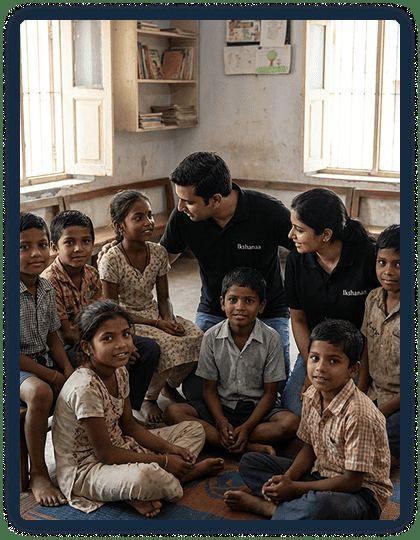 Ikshanaa volunteers in black branded shirts sitting with children during a classroom session